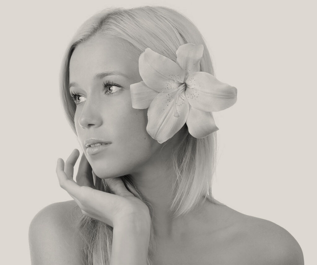 Woman with a large flower in her hair looking to the side