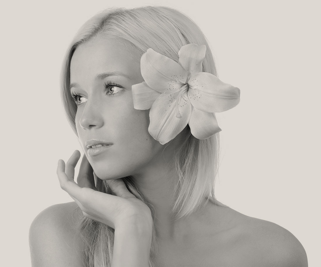 Woman with a large flower in her hair looking to the side