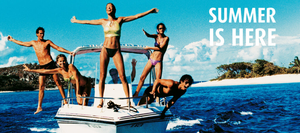 Group of friends jumping into the air on a sunny beach