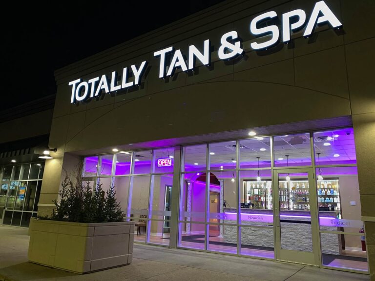 Totally Tan & Spa tanning salon storefront illuminated at night