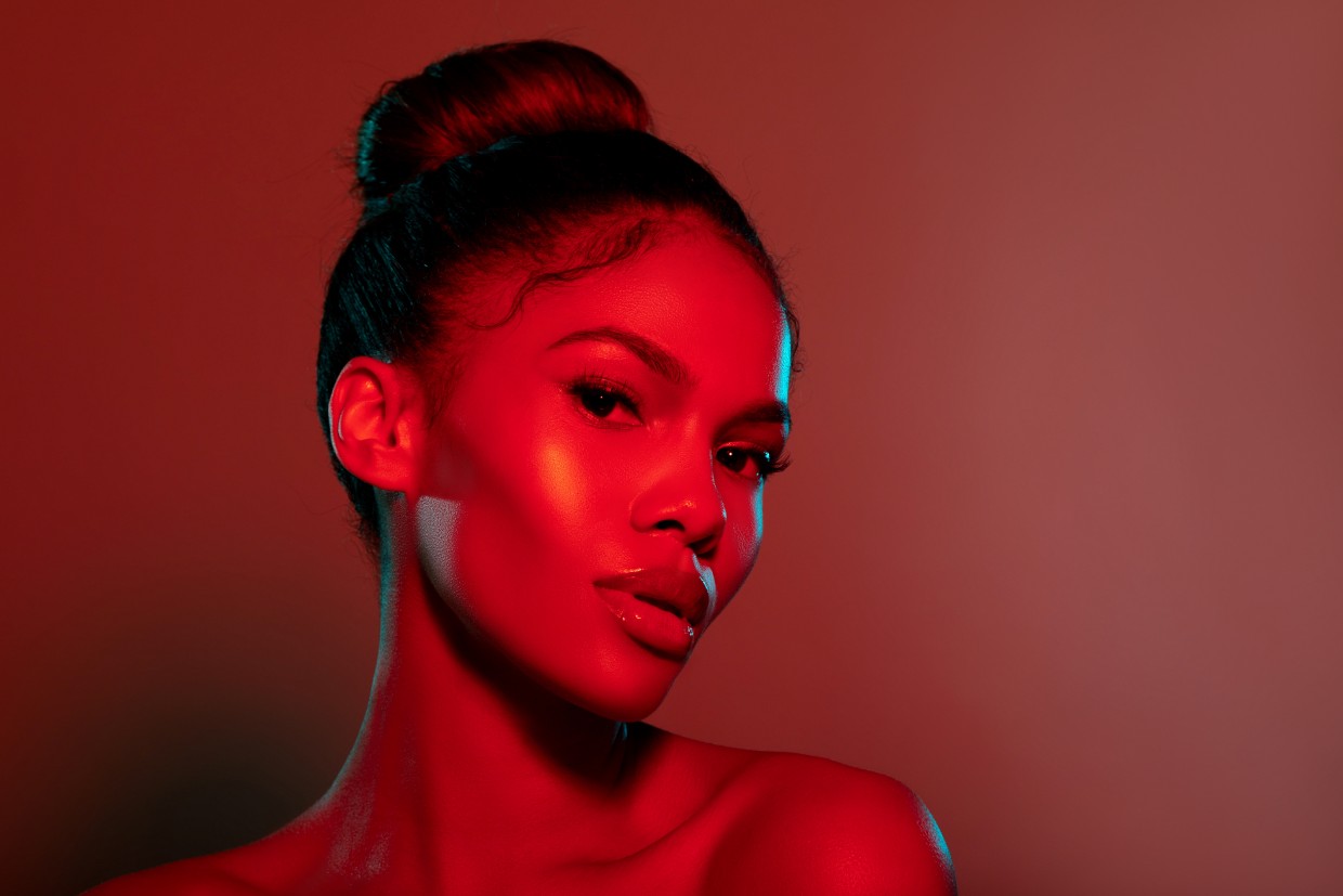 beauty portrait of woman illuminated with red light therapy glow