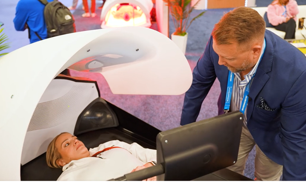 JK Products and Services Salesman, Andy Dunn pictured with Customer on Wellsystem Hydrowave auto-massage bed at HFA 2025.